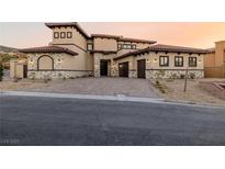 Stunning exterior of a luxury home featuring a three-car garage and a beautiful stone driveway at 19 Rue Grimaldi Way, Henderson, NV 89011