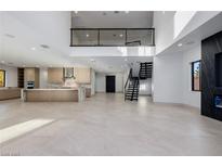 Bright and airy living space featuring an open floor plan, modern staircase, and sleek fireplace at 19 Rue Grimaldi Way, Henderson, NV 89011