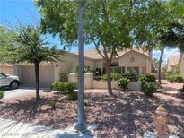 Charming single-story home featuring a tiled roof, two-car garage, and meticulously maintained desert landscaping at 2465 Palmridge Dr, Las Vegas, NV 89134