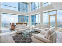 Bright living room with floor-to-ceiling windows and modern white sofas with a beautiful city view at 2700 Las Vegas Blvd # 4305, Las Vegas, NV 89109