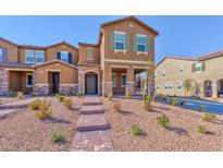 Charming townhome with stone accents, a brick walkway, and desert landscaping at 2887 Starling Summit St, Henderson, NV 89044