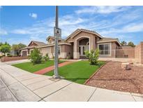 Charming single-story home featuring an arched entryway and manicured front lawn at 4537 Colonial Canyon St, North Las Vegas, NV 89031