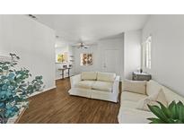 Bright living room with wood floors, neutral walls and white sofas adjacent to a breakfast bar with stools at 5250 S Rainbow Blvd # 2070, Las Vegas, NV 89118