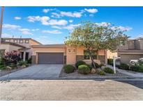Inviting single-story home featuring a two-car garage, landscaped front yard, and stone accents at 5384 Candlespice Way, Las Vegas, NV 89135