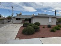 Charming single-story home featuring a well-maintained lawn and an expansive concrete driveway at 6205 Parsifal Pl, Las Vegas, NV 89107