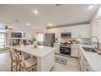 Modern kitchen featuring white cabinets, stainless steel appliances, and a large center island with seating at 8136 Shady Glen Ave, Las Vegas, NV 89131