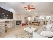 Spacious living room featuring a stone fireplace, ceiling fan, and an open floor plan at 8136 Shady Glen Ave, Las Vegas, NV 89131