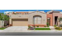 Single-story home showcasing a two-car garage, desert landscaping, and a neutral color palette at 9215 Penn Station St, Las Vegas, NV 89123