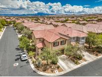 Gorgeous aerial view of a home and neighborhood featuring lush landscaping and scenic mountain views at 10294 Running Falls St, Las Vegas, NV 89178