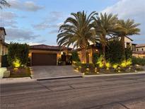 Beautiful front exterior with lush landscaping and a paver driveway creating curb appeal at 11318 San Arezzo Pl, Las Vegas, NV 89141