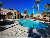 Resort-style pool and lounge area surrounded by lush landscaping and palm trees on a sunny day at 1150 N Buffalo Dr # 2093, Las Vegas, NV 89128
