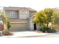 Two-story home with a neutral-colored exterior, attached garage, and easy to maintain landscaping at 2749 Invermark St, Henderson, NV 89044