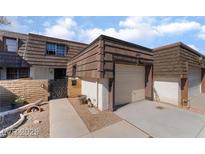 Charming townhome featuring private garages, stylish wood shingles, and a walkway leading to a decorative front gate at 2967 Pinehurst Dr, Las Vegas, NV 89109