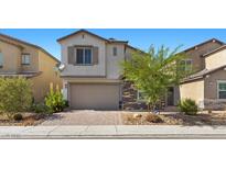 Beautiful two-story home with a brick driveway, tan stucco, stone facade, and a two-car garage at 6854 Chargehand Ave, Las Vegas, NV 89156