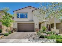 Charming two-story stucco home featuring a brick driveway, desert landscaping, and attached two-car garage at 7246 Dazzle Point St, North Las Vegas, NV 89084