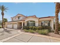Inviting two-story home with a three-car garage, lovely landscaping, and a charming walkway at 8104 Wispy Sage Way, Las Vegas, NV 89149