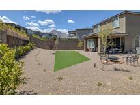 Spacious backyard featuring gravel landscaping, a small grassy patch, fire pit, and outdoor seating area at 12429 Alpenglow Ct, Las Vegas, NV 89138