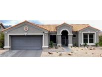 Inviting single-story home with a desert landscape, featuring a terracotta tile roof and gray exterior paint at 2625 Youngdale Dr, Las Vegas, NV 89134