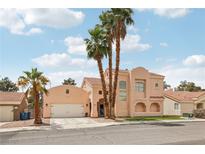 Charming two-story home with desert landscaping, palm trees and a spacious front yard under a blue sky at 2809 Du Barry Manor Ln, Las Vegas, NV 89108