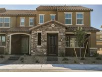 Inviting two-story townhome featuring a stone facade, covered porch, and manicured landscaping at 3240 Avernus Ave, Henderson, NV 89044