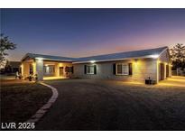 Charming single story home with a brick exterior, covered porch and well manicured lawn and mature landscaping at 3950 Oakridge Ave, Pahrump, NV 89048
