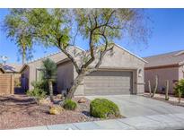 Charming home featuring xeriscape landscaping, a mature tree, and a two-car garage at 4124 Gliding Gulls Ave, North Las Vegas, NV 89084