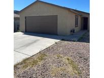 Tan single story house with brown two car garage door and front door at , Las Vegas, NV 89106