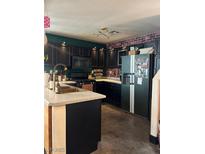 Updated kitchen with black cabinetry, modern appliances, and stylish brick accent wall at 10403 Fancy Fern St, Las Vegas, NV 89183