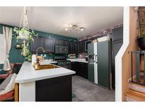 Stylish kitchen features dark cabinetry, modern appliances, and a unique, custom design for a contemporary look at 10403 Fancy Fern St, Las Vegas, NV 89183