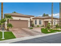 Tan stucco home with a tile roof, brown trim, desert landscaping, and a two-car garage at 10408 Mezzanino Ct, Las Vegas, NV 89135