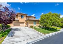 Inviting stucco two-story home with a well-manicured lawn, mature trees, and a spacious driveway and 2-car garage at 17 Stonemark Dr, Henderson, NV 89052