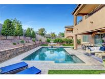 Inviting backyard featuring a sparkling pool, lounge chairs, patio seating, and well-maintained landscaping at 305 Rezzo St, Las Vegas, NV 89138