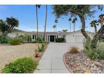 Stunning single-story home featuring mature landscaping, a circular driveway, and a symmetrical facade at 3175 S Torrey Pines Dr, Las Vegas, NV 89146