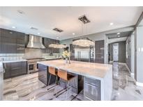Modern kitchen featuring a large center island, stainless steel appliances, and stylish gray cabinetry at 3552 Coventry Gardens Dr, Las Vegas, NV 89135