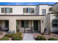 Charming home featuring a covered front porch, neutral stucco facade, and green shutters on the windows at 3585 Arcadian Sea St, Las Vegas, NV 89106