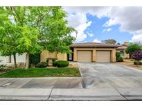 Charming single-story home with a two-car garage, lush landscaping, and desert-friendly greenery at 4 Chatmoss Rd, Henderson, NV 89052