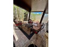 Inviting covered patio featuring wicker furniture and a cozy outdoor seating area at 4662 Kelly Barry Way, Las Vegas, NV 89121