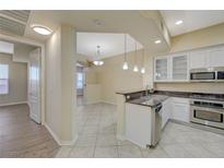 Open kitchen with stainless steel appliances, granite countertops, and bright lighting fixtures at 50 E Serene Ave # 420, Las Vegas, NV 89123