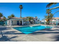 Community pool with clear blue water and shade, surrounded by palm trees and well-maintained landscaping at 5024 Starfinder Ave, Las Vegas, NV 89108