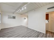 Bright living room with wood-look floors and white painted wood beam ceiling at 701 Harvard St, Las Vegas, NV 89107