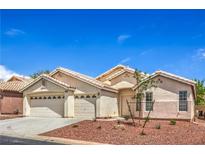 Inviting single-story home featuring a three-car garage, desert landscaping, and neutral stucco exterior at 8664 Frasure Falls Ave, Las Vegas, NV 89178