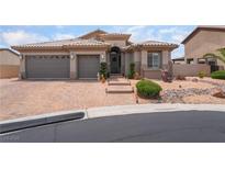Charming home featuring a landscaped front yard, a paver driveway and a three-car garage at 8911 Lansberry Ct, Las Vegas, NV 89147