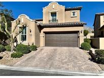 Charming two-story home with a brown garage door, landscaped yard and brick driveway at , Las Vegas, NV 89138
