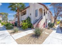 Condo's exterior shows neat landscaping and walkways leading up to the units on a sunny day at 1751 E Reno Ave # 206, Las Vegas, NV 89119