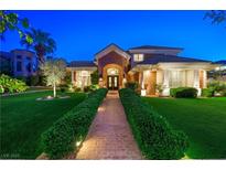 Stunning brick home featuring a manicured front lawn with mature trees and a brick pathway leading to the entrance at 2325 Prometheus Ct, Henderson, NV 89074