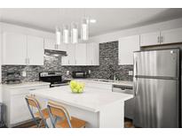 Modern kitchen features stainless steel appliances, center island, stone countertops, and attractive backsplash at 3208 Alcoa Ave, Las Vegas, NV 89102
