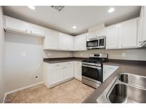 Bright kitchen features stainless steel appliances, white cabinets, and durable countertops at 6868 Sky Pointe Dr # 1112, Las Vegas, NV 89131
