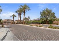 A grand entrance to the Finisterre neighborhood lined with tall palm trees on a beautiful, sunny day at 7719 Villa Montara St, Las Vegas, NV 89123