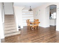 Inviting dining room features wood floors, a striped accent wall, and a traditional wood dining set, perfect for Gathering meals at 9303 Gilcrease Ave # 1077, Las Vegas, NV 89149