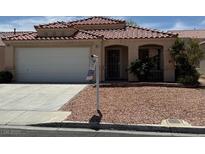 Charming single-story home with a red tile roof, well-maintained landscaping, and a two-car garage at 951 Country Back Rd, Las Vegas, NV 89123
